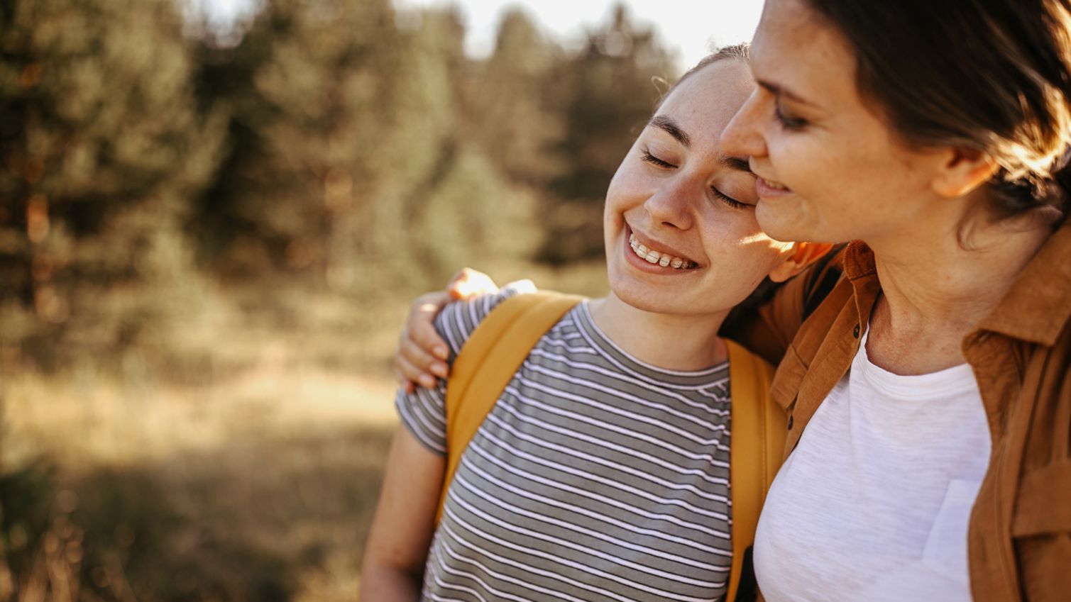 Mom and daughter hug outside